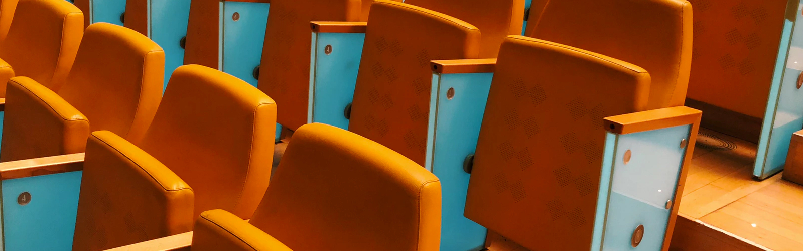 Close up shot of an auditorium with orange chairs