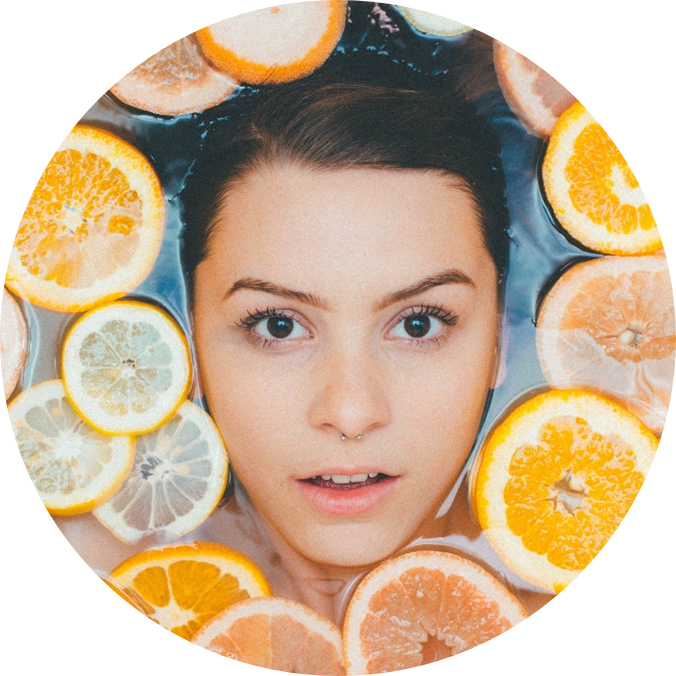 closeup faceshot of cook floating in a pool of water filled with orange slices